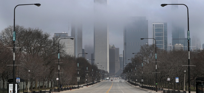Fog lifts over Chicago and the usually busy Columbus Drive after people were ordered to stay at home. Illinois Gov. JB Pritzker's office estimates the budget shortfall for 2021 will top $6 billion because of the coronavirus-fueled economic downturn.