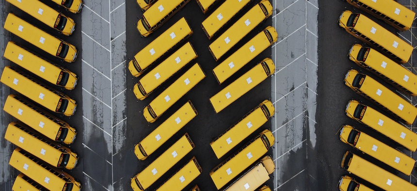 School buses sit parked in a lot as schools remain closed due to the coronavirus Monday, March 30, 2020, in Providence, R.I