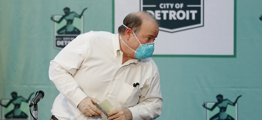 Detroit Mayor Mike Duggan exits a news briefing in April after announcing layoffs, pay cuts for other employees and and a reduction in some services. On Monday, he said up to 200 workers would soon return to their normal duties.