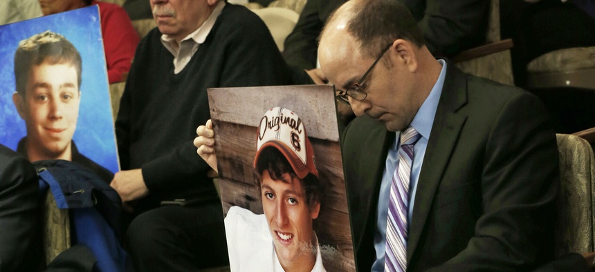 Greg LaVallee, right, testifies at a legislative hearing in Minnesota last year, holding a photo of his son, who was killed by a driver who was using a cellphone.