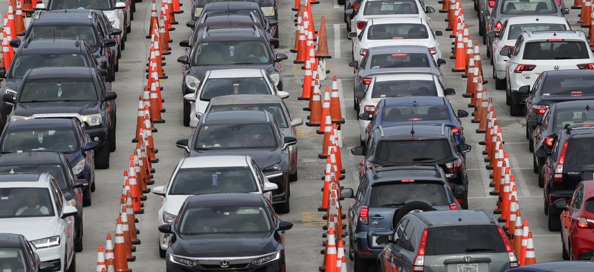 Lines of cars wait at a drive-through coronavirus testing site on July 5, 2020, outside Hard Rock Stadium in Miami Gardens, Fla.