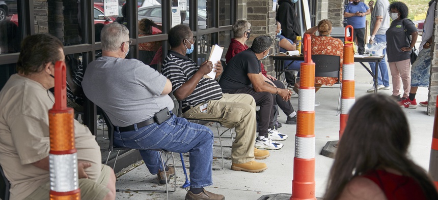 Job seekers exercise social distancing as they wait to be called into the Heartland Workforce Solutions office in Omaha, Neb., Wednesday, July 15, 2020.