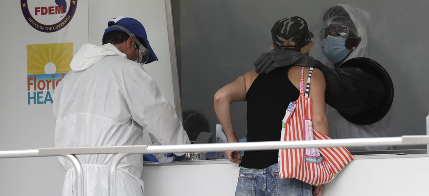 A woman is tested for COVID-19 at a walk-up testing site during the coronavirus pandemic, Friday, July 17, 2020, in Miami Beach, Fla.