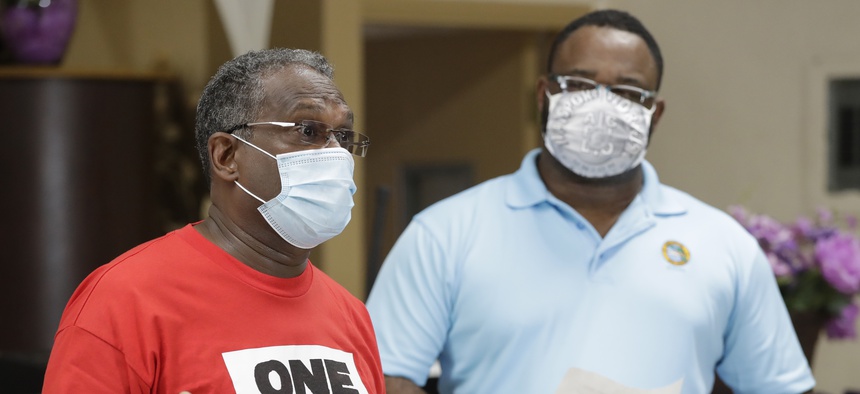 Alec Smith, left, who was laid off in March from Fort Lauderdale-Hollywood International Airport, shares his frustration that he still hasn't been able to get unemployment, as he speaks at a June news conference.