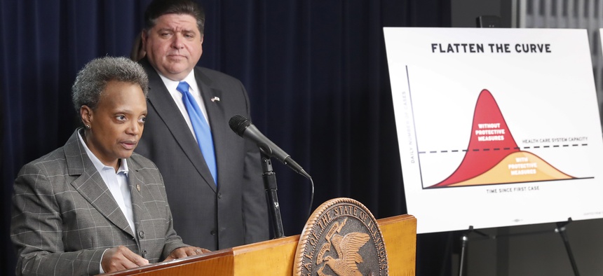 Chicago Mayor Lori Lightfoot and Illinois Gov. J.B. Pritzker appear together at a press conference in March 2020. As Covid-19 data inequities were discovered, Gov. Pritzker and Mayor Lightfoot launched services to better support Black residents.