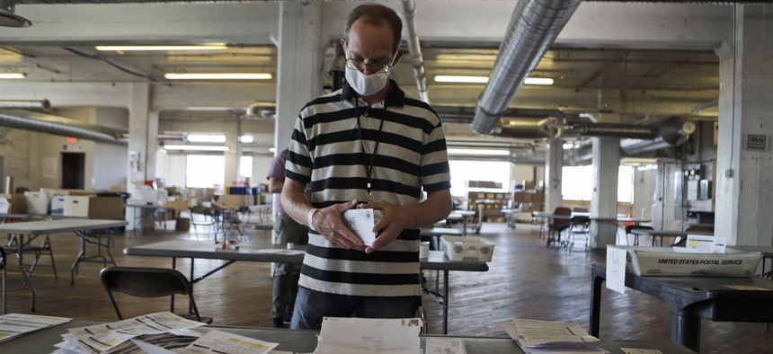 Mike Babinski opens applications for voter ballots at the Cuyahoga County Board of Elections Tuesday, July 14, 2020, in Cleveland.