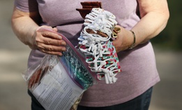 A Des Moines Area Quilters Guild member drops off completed face masks to be distributed to Des Moines Public Schools students, Thursday, July 30, 2020, in Des Moines, Iowa. (AP Photo/Charlie Neibergall)