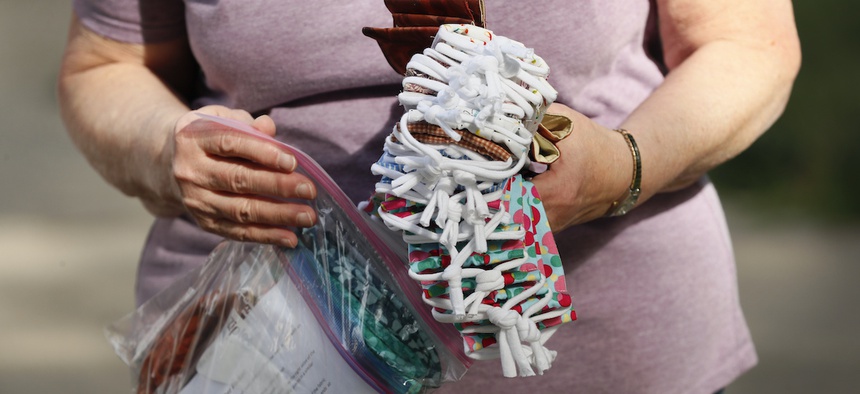A Des Moines Area Quilters Guild member drops off completed face masks to be distributed to Des Moines Public Schools students, Thursday, July 30, 2020, in Des Moines, Iowa. (AP Photo/Charlie Neibergall)