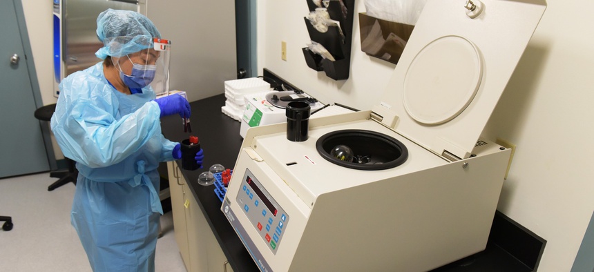 A University of Miami Miller School of Medicine lab technician processes blood samples in the specimen processing lab from study participants who volunteered to take part in testing the NIH-funded Moderna Covid-19 vaccine in Miami, Florida.