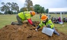 Workers sift through dirt excavated in the Oaklawn Cemetery in Tulsa, Oklahoma.