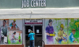 In this May 7, 2020 file photo, a person looks inside the closed doors of the Pasadena Community Job Center in Pasadena, Calif., during the coronavirus outbreak.