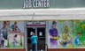 In this May 7, 2020 file photo, a person looks inside the closed doors of the Pasadena Community Job Center in Pasadena, Calif., during the coronavirus outbreak. 