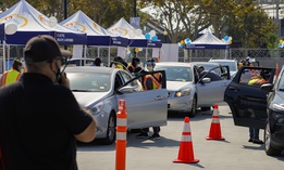 People wait inside their vehicles to get their influenza vaccine during a free drive-thru flu vaccination event at the Exposition Park in Los Angeles, Saturday, Oct. 17, 2020.
