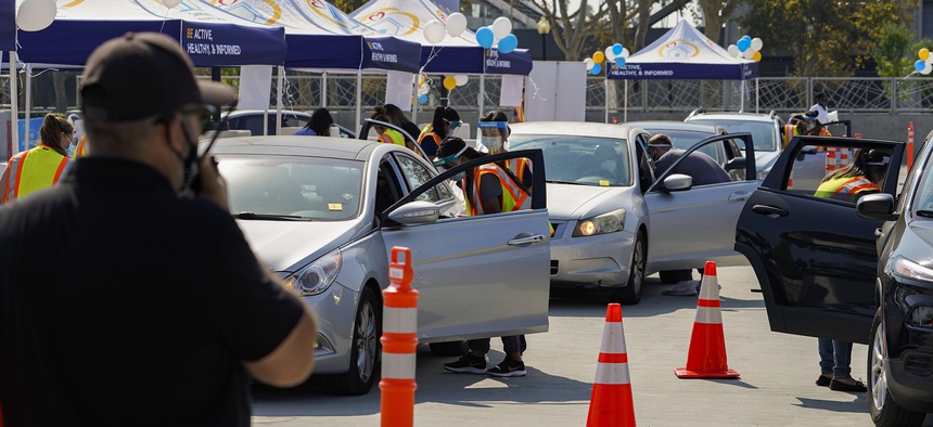 People wait inside their vehicles to get their influenza vaccine during a free drive-thru flu vaccination event at the Exposition Park in Los Angeles, Saturday, Oct. 17, 2020.