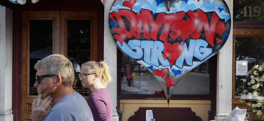 Pedestrians pass a makeshift memorial for the slain and injured victims of a mass shooting that occurred in Dayton, Ohio in August 2019.