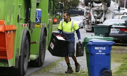 David Morales, a garbage driver with Recology, picks up a garbage container for Seattle Public Utilities, Friday, April 15, 2016, in Seattle.