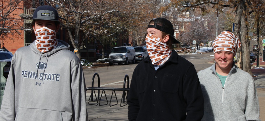 College students Colin Berg (left), Connor Dreher and Brady Bowman stroll through downtown Boulder, Colorado, in mid-November wearing matching neck gaiters.