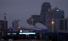 A sign about social distancing stands against the downtown skyline Tuesday, March 24, 2020 on the first day of a stay-at-home order in Kansas City, Mo. 
