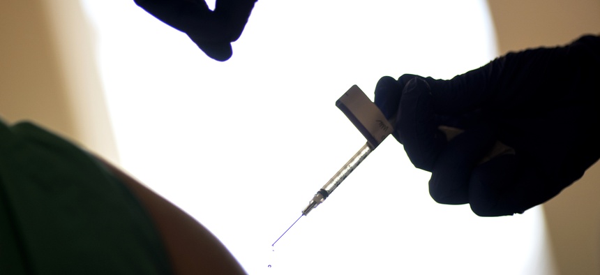 In this Tuesday, Dec. 15, 2020 file photo, a droplet falls from a syringe after a health care worker was injected with the Pfizer-BioNTech COVID-19 vaccine at Women & Infants Hospital in Providence, R.I.