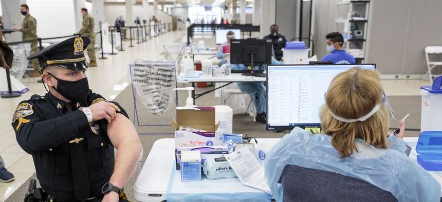 Sergeant Michael Zarro, of the Mount Olive, NJ, Police Department, rolls up his sleeve to receive a COVID-19 vaccination at one of the state's two vaccine megasites in Morris County, NJ on Friday, Jan. 8, 2021.
