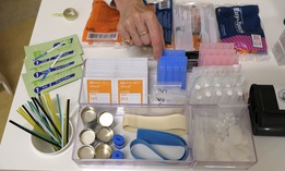 In this Aug. 29, 2018 file photo, Linda Montel shows off supplies on a check in desk at Safer Inside, a realistic model of a safe injection site in San Francisco.