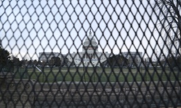  Police and National Guard stand watch over the United States Capitol building which now stands complete with non-scalable fencing and concrete barriers.