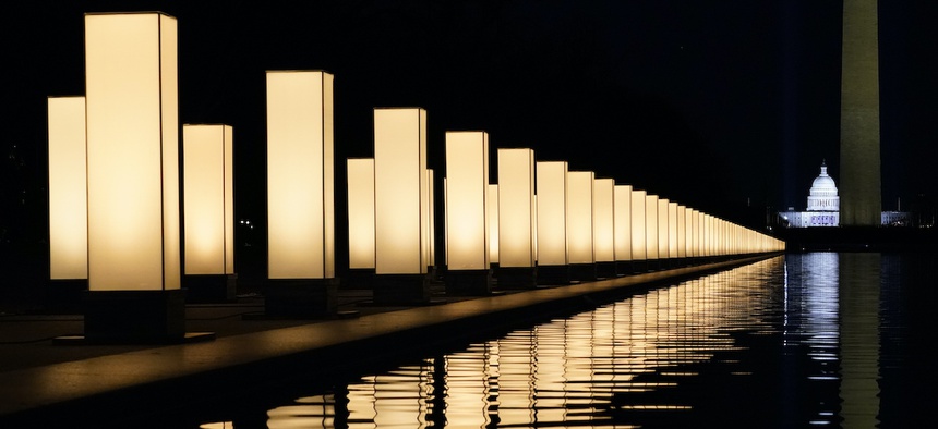 Lights surround the Lincoln Memorial Reflecting Pool, placed as a memorial to COVID-19 victims Tuesday, Jan. 19, 2021, in Washington, after President-elect Joe Biden spoke, with the Washington Monument and the U.S. Capitol in the background.