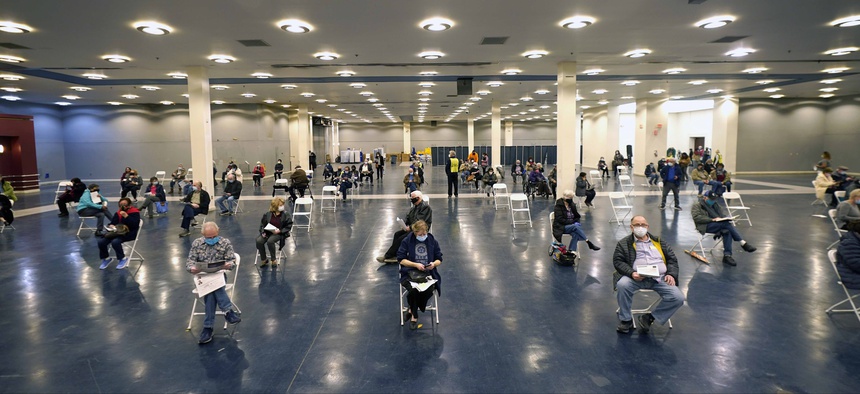 People that received a COVID-19 vaccine socially distance as they wait the required fifteen minutes to monitor for adverse reactions after getting the shot at the Dallas County mass vaccination site at Fair Park Wednesday, Jan. 20, 2021.