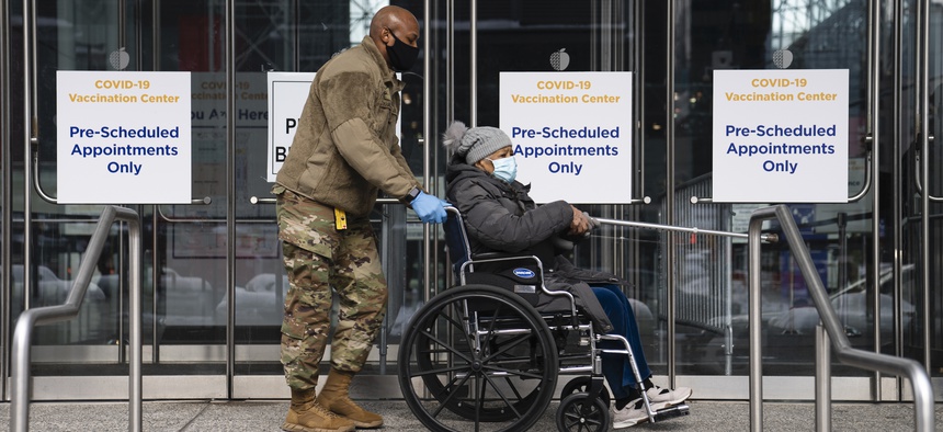 Patients are offered wheel-chairs by the National Guard at a COVID-19 vaccination site inside the Jacob K. Javits Convention Center, Wednesday, Feb. 3, 2021, in the Manhattan borough of New York.