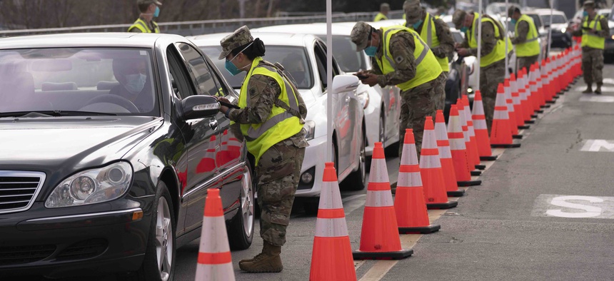 Members of the National Guard help motorists check in at a federally-run COVID-19 vaccination site set up on the campus of California State University of Los Angeles in Los Angeles, Tuesday, Feb. 16, 2021.