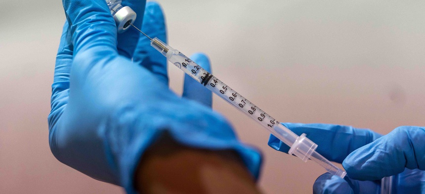 In this Jan. 31, 2021 photo, a pharmacist fills a dead volume syringe with the Pfizer-BioNTech COVID-19 vaccine at a pop-up COVID-19 vaccination site at the Bronx River Houses Community Center, in the Bronx borough of New York.