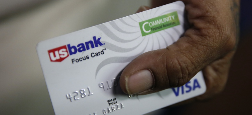 Susie Garza displays the city provided debit card she receives monthly through a trial program in Stockton, Calif. A study of people in California who received $500 a month for free says they used it to pay off debt and get full-time jobs.