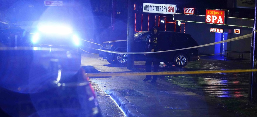 An official stands in front of a massage parlor after a shooting, late Tuesday, March 16, 2021, in Atlanta. Authorities say shootings at three Atlanta-area massage parlors have left several people dead, many of them women of Asian descent.